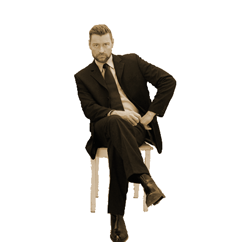 Master Andre alias Dominus.Berlin auf Stuhl und in Business Outfit mit Anzug und Krawatte