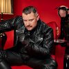 SM Master Dominus.Berlin alias Master Andre in Leder Outfit in Salon rot mit Sklave in Rubber und Sekt Glas