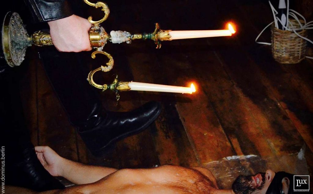 Wachsspiele wax play: Der Gay SM Master Andre foltert sein devoten nackten Sklaven mit heißem Kerzenwachs.