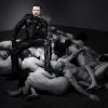 BDSM Aktion des Dominus Berlin alias Master Andre in Vollleder auf Nackt Sklaven sitzend in Machtausuebung